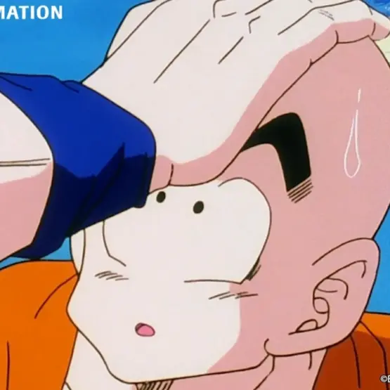 Kuririn de uniforme laranja recebe uma mão sobre a cabeça em uma cena de Dragon Ball