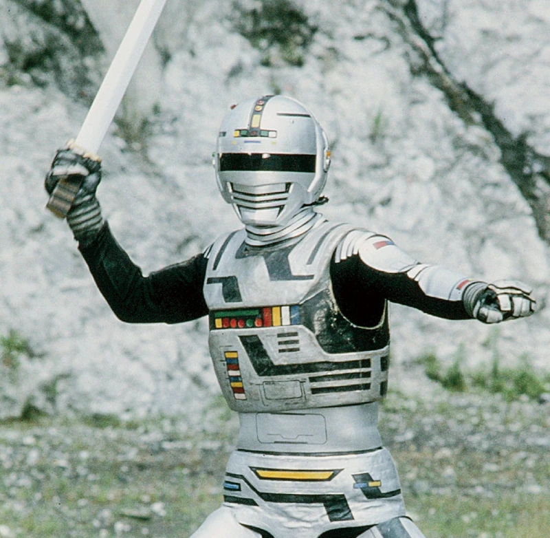 Gavan com armadura prateada e espada em uma locação rochosa